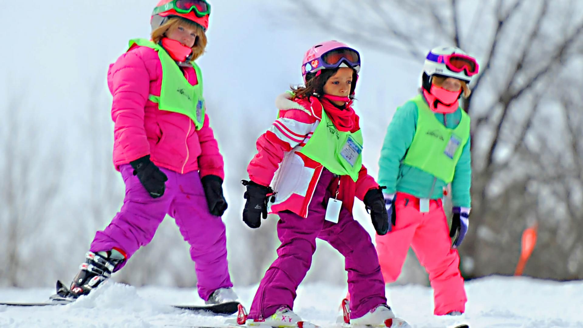 Three young skiers learning how to ski in the Mountain Cats Program
